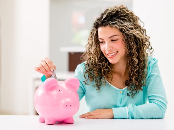 Woman depositing money piggy bank