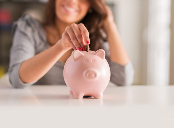 Woman putting Money Piggy Bank
