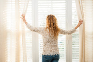 Woman Opening Blinds