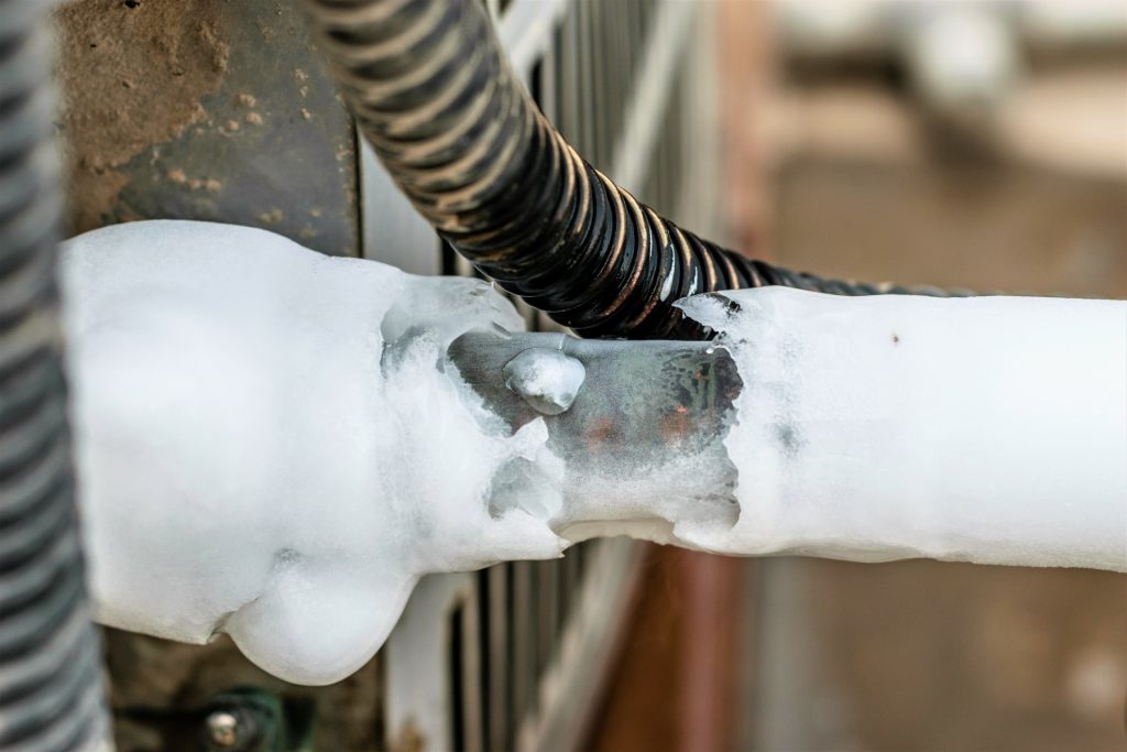 Close-up shot of ice forming on the manifold gauge line due to the low pressure phenomenon causes the temperature to drop as well, thus creating ice.